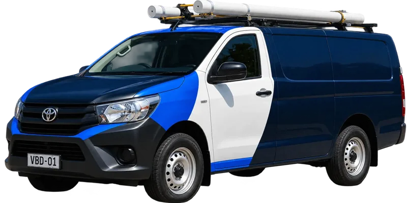 A licensed Coogee plumbing van loaded with pipe on the roof rack